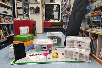 Makerboxen und andere Materialien aufgereiht auf dem Boden der Bibliothek