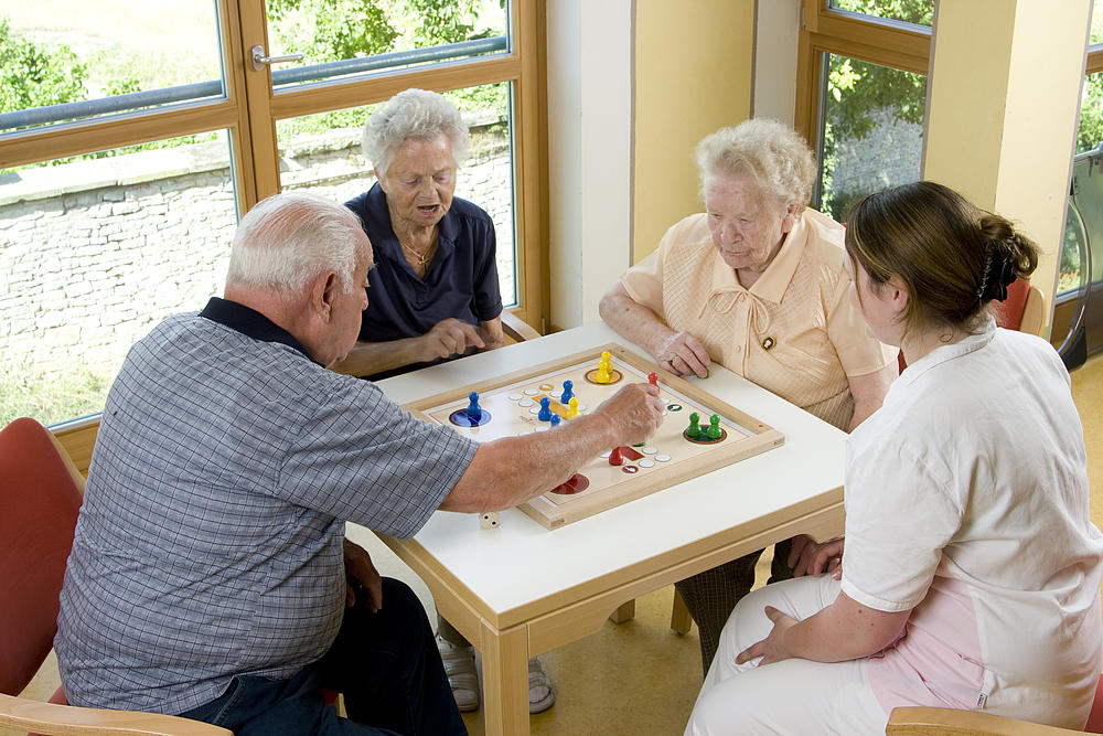 Senior*innen spielen ein Brettspiel.